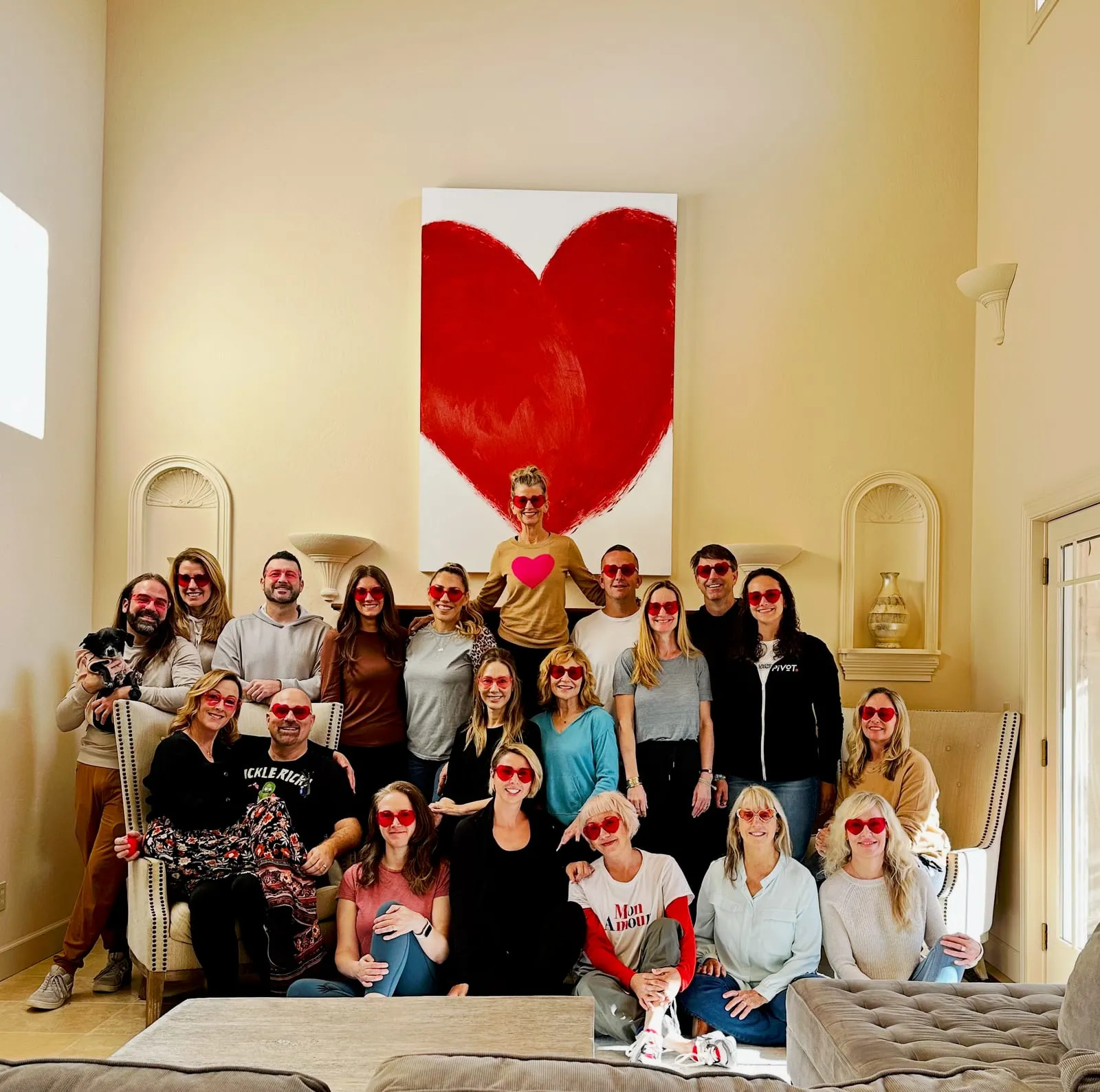 A joyful group of PIVOT community members in heart-shaped glasses, gathered together