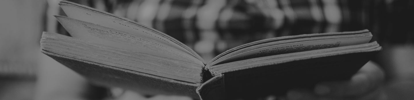An open book with pages turning, in black and white