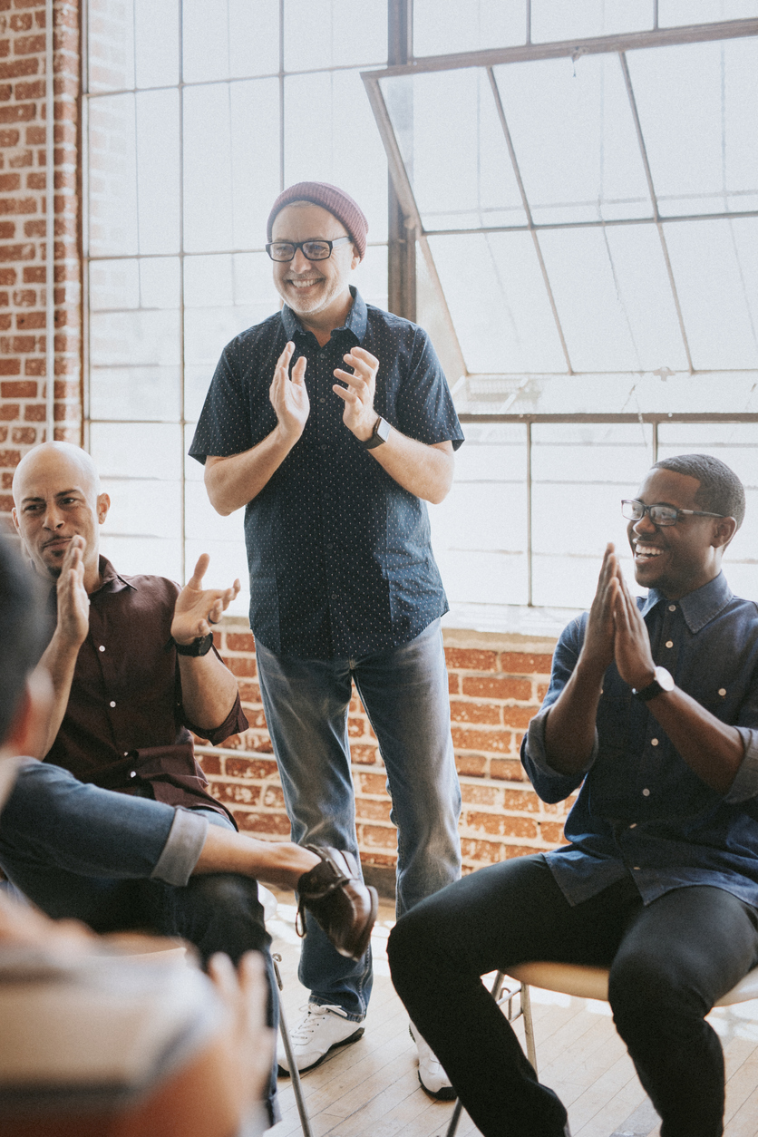 Men in a group therapy session at a PIVOT retreat